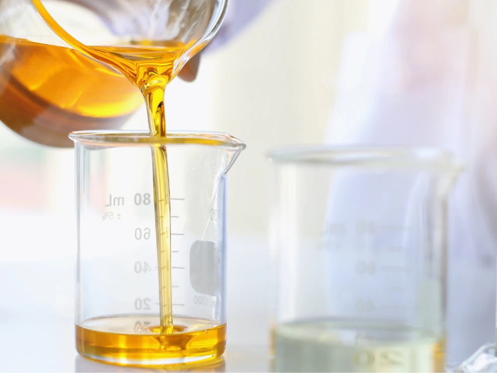 Scientist Pouring Golden Complex Oil Into Beaker